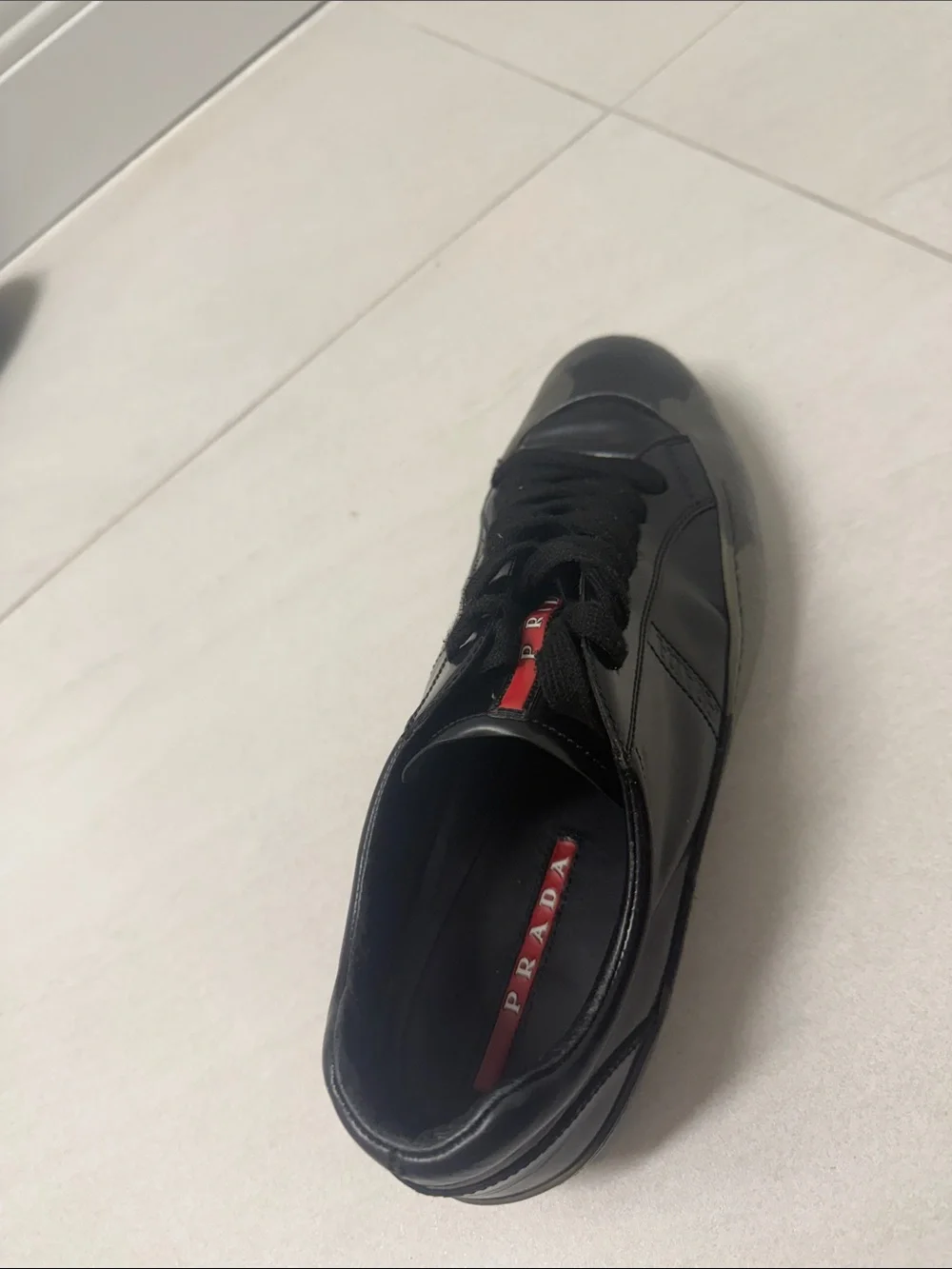 Prada Black Low-Top Leather Sneaker with Red Tongue Accent